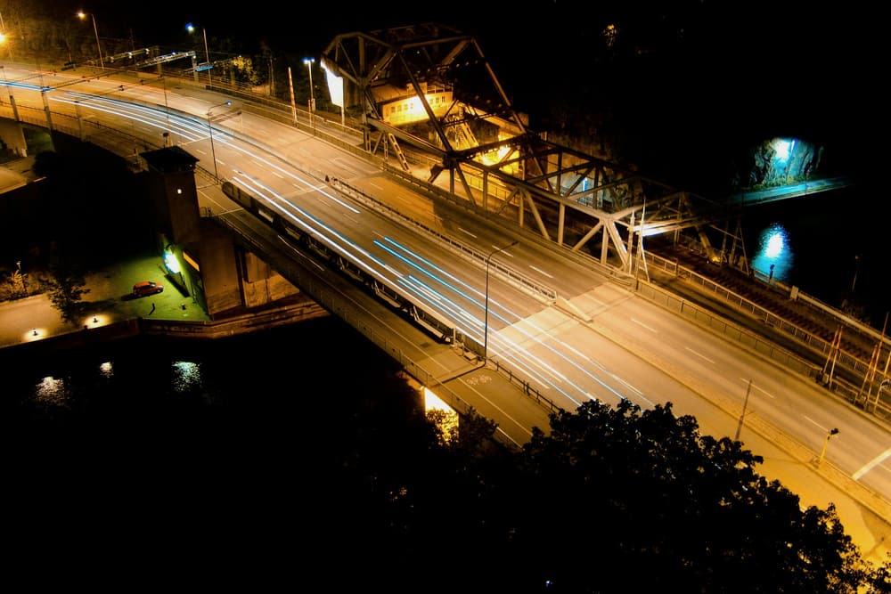Bro i Stockholm med ljusspår från trafiken på kvällen